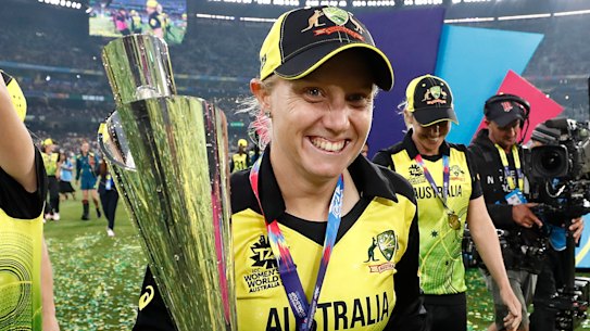 Alyssa Healy celebrates with the World Cup trophy.
