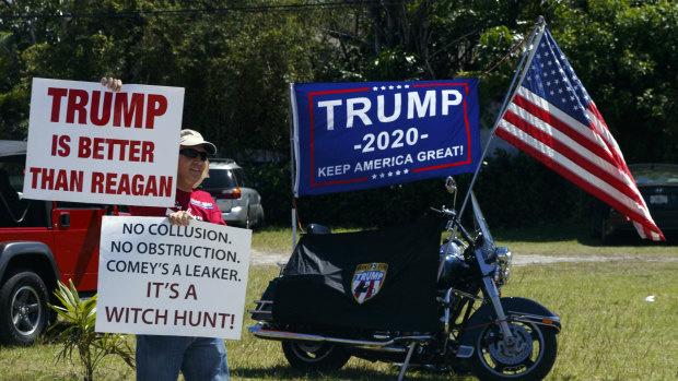 A supporter of US President Donald Trump awaits his motorcade in West Palm Beach, Florida, on Saturday.