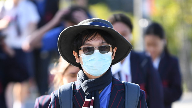 A Brisbane school student wears a surgical mask as he arrives for the first day of face-to-face schooling on Monday.