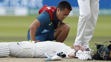 Steve Smith receives medical assistance after being hit in the neck by Jofra Archer. He left the field but returned to bat once Peter Siddle was dismissed. 