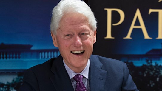 Former President Bill Clinton smiles as he signs autographs during an event to promote his new novel with author James Patterson, The President is Missing.