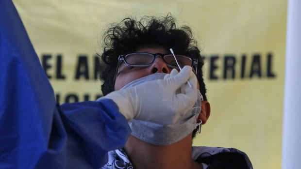 A man gets a nasal swab for a rapid COVID-19 test at a post set up in Mexico City.