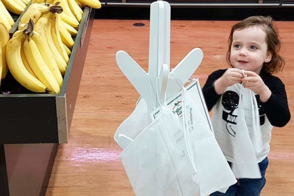 Charlie Barns, 4, refills the reusable produce bag station. 