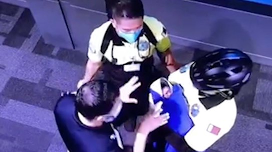 A surveillance image, obtained by Doah News,  shows officials holding an allegedly abandoned baby at Hamad International Airport. 