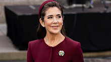 Queen Mary wore a new burgundy suit by French designer Roland Mouret and a hat by Danish milliner Katrin Cecilia Jacobsen.