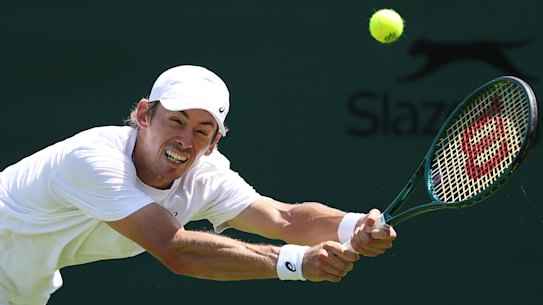 De Minaur stretches for a ball in practice.