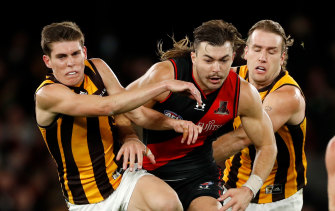 Aggression: Draper bursts through his Hawthorn opponents
