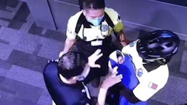 A surveillance image, obtained by Doah News,  shows officials holding an allegedly abandoned baby at Hamad International Airport. 