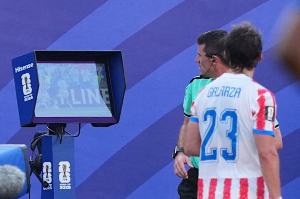Referee Ilgiz Tantashev checks the VAR monitor.