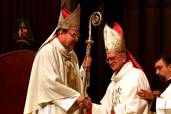 The incoming Archbishop of Sydney George Pell receives the staff from his predecessor Edward Clancy in May 2001.