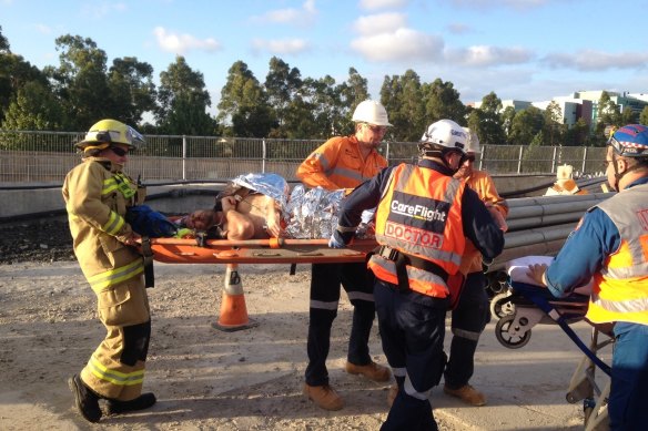 A welder on the North West Metro, injured by a falling boulder, is put on a stretcher.