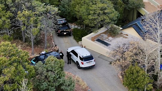 Law enforcement officials talk outside the home of actor Gene Hackman and his wife Betsy Arakawa.