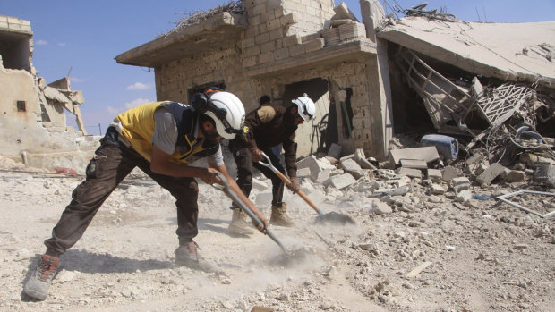 Volunteer rescuers clean rubble from a house damaged by a Syrian government air strike in Hobeit , near Idlib.