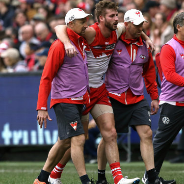 Alex Johnson is helped off the field after injuring his anterior cruciate ligament while playing for the Swans in 2018.