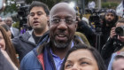 Democratic Senator Raphael Warnock poses with supporters during an election day event in Norcross, Georgia.