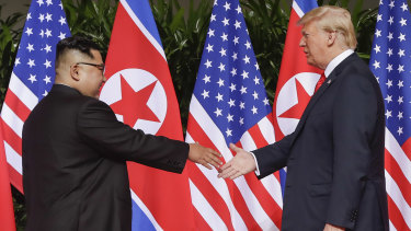 President Donald Trump reaches to shake hands with North Korea leader Kim Jong-un at the Capella resort on Sentosa Island in Singapore.