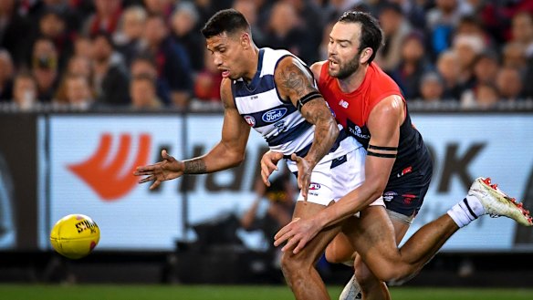 Demon Jordan Lewis pressures Geelong's Tim Kelly.