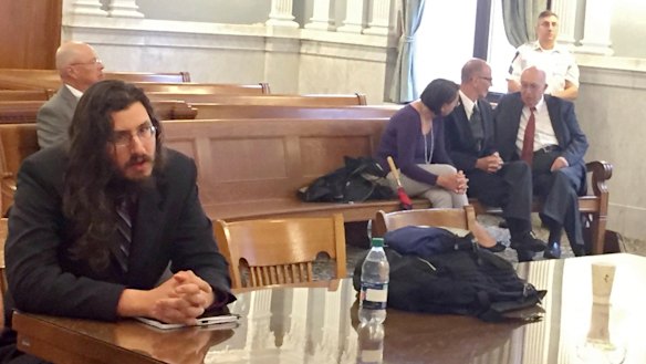 Michael Rotondo, left, in court during an eviction proceeding in Syracuse, New York, brought by his parents, Mark and Christina, of Camillus. The parents confer with their lawyer, Anthony Adorante, in the court gallery behind. 
