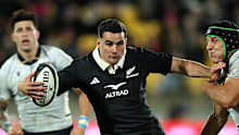 Josh Moorby of the New Zealand All Blacks is tackled.