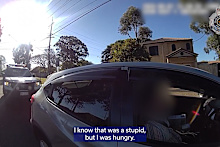 A Queensland driver was slapped with a hefty fine for allegedly steering with his knees while buttering a bagel.