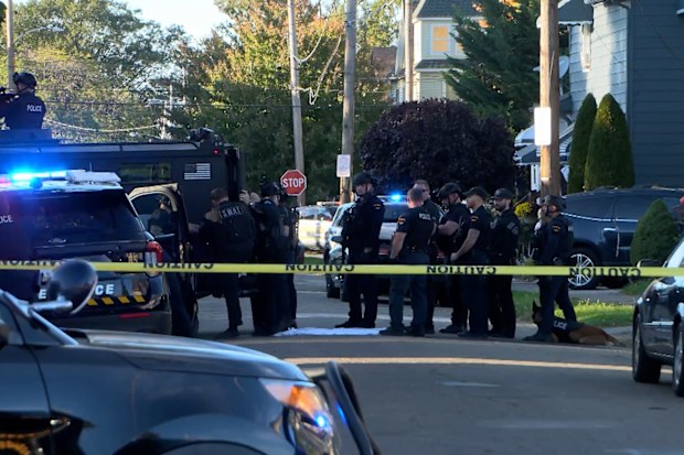 Police gather outside the scene.