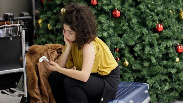 A woman waits in the departures area at Gatwick Airport.