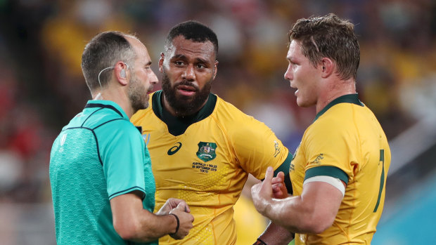 Referee Romain Poite speaks with Samu Kerevi and captain Michael Hooper during Australia's match with Wales. 