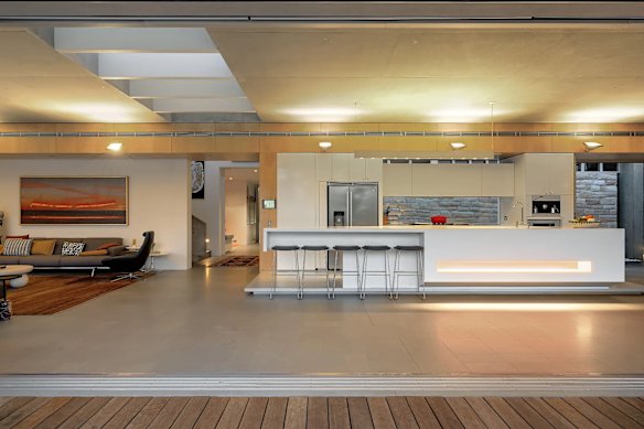 The industrial-style waterfront home is a blend of concrete, glass and timber.
