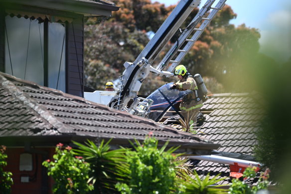 Emergency services rescuing the helicopter pilot from the wreckage.