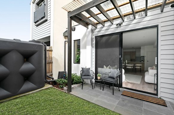 The rear garden features a rainwater tank and small al fresco area.