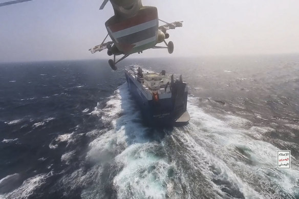 A Houthi helicopter approaches a cargo ship in the Red Sea.