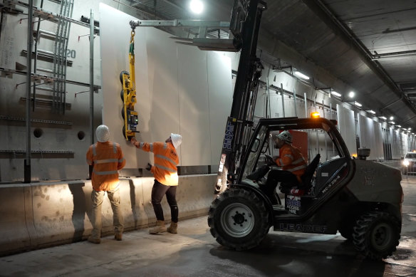 Co<em></em>nstruction workers install panels in one of the tunnels.