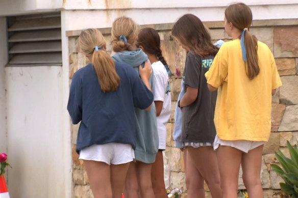 Mourners gather at the site where Stella Berry died after being attacked by a shark. 