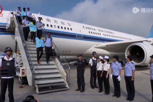 中国警察蒙面护送涉嫌网络诈骗的人2017 年从斐济飞往中国的一架飞机。 
