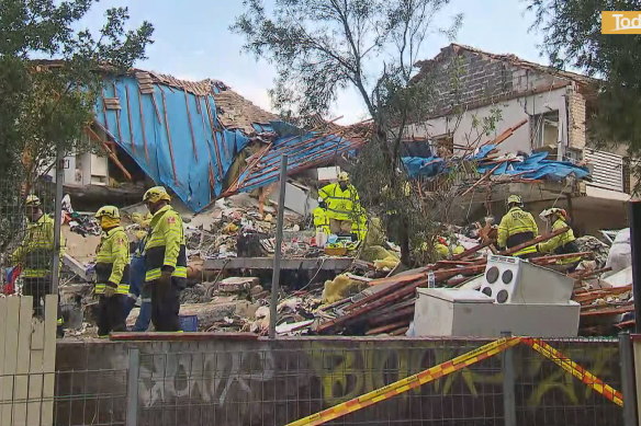 Rescuers go through the debris of the Whalan townhouse that exploded on Saturday.