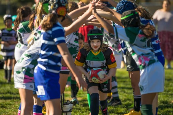 Girls run through a tunnel at the Frosty 7’s Girls Rugby tournament.