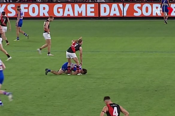 Essendon’s Darcy Parish signals for assistance after Tom Liberatore collapsed.