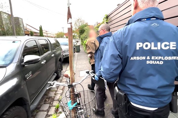 Detectives from the Arson and Explosives Squad arrest the man on Thursday. 