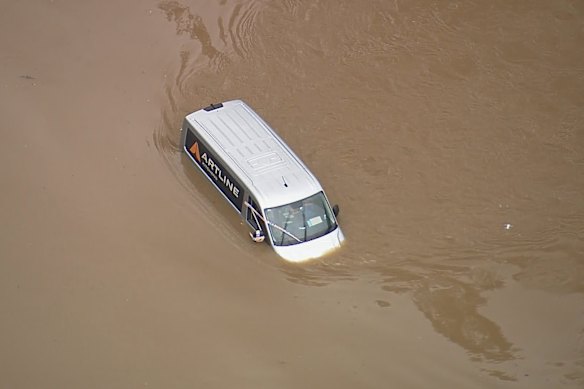 The SES rescued a passenger and his dog trapped in floodwaters from this  vehicle on Moreton Park Road in Douglas Park early on Thursday. 