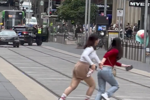 Pedestrians race across Bourke Street to avoid an erratic driver on Thursday. 