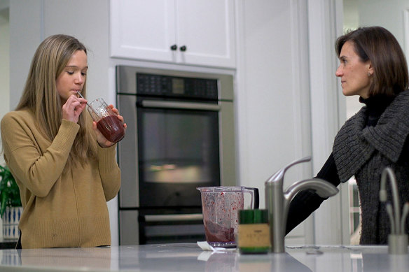 Nina Nichols, 18, takes her daily dose of Palforzia, mixed in a smoothie, as her mother, Maria Acebal watches, in her home in Washington.