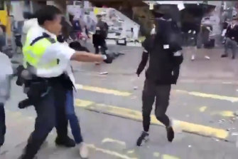 The video captures the moment a Hong Kong policeman holds onto one protester and shoots a second protester, who was later hospitalised.