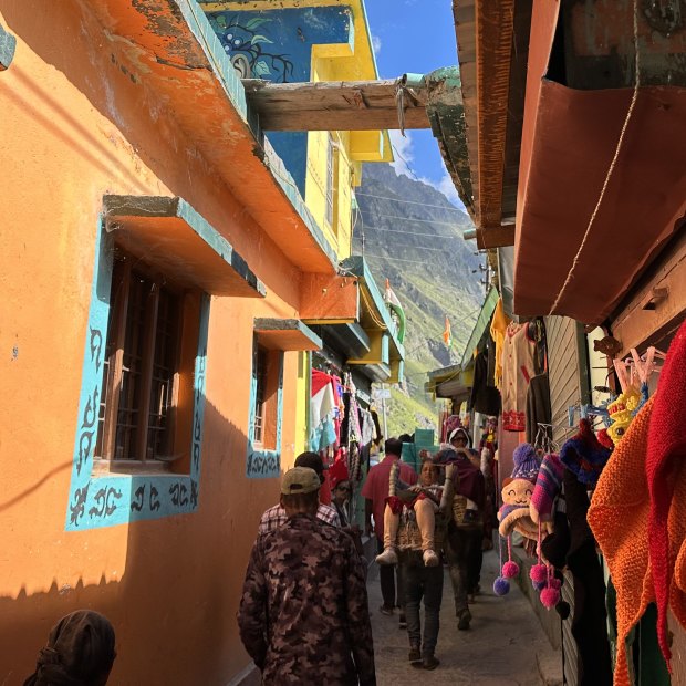 A pilgrim is carried through Mana village.