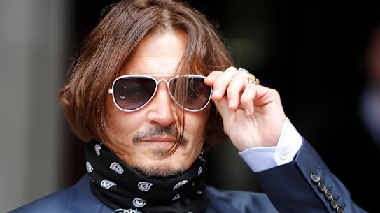 Johnny Depp arrives at the High Court in London on Friday. He is suing the publisher of The Sun newspaper for depicting him as a "wife beater".