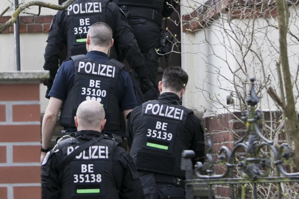 Police officers enter a house during a raid in Berlin, Germany.