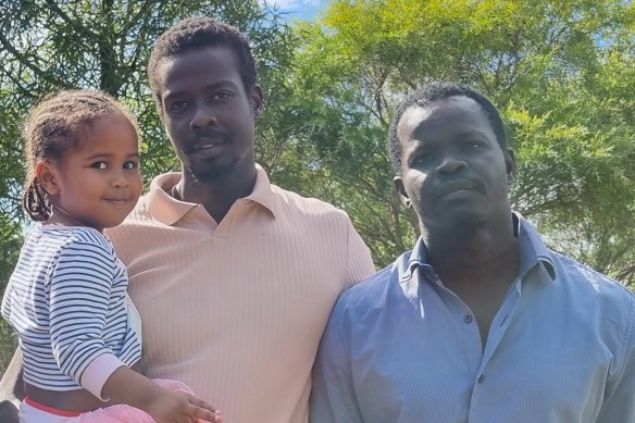Deng’s son Dut, holding his cousin Sunday, pictured with his uncle, Ayik Chut Deng. 