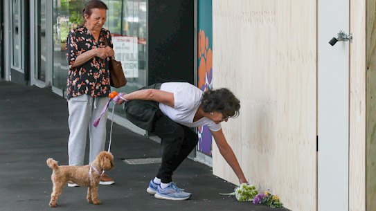 Geraldine Maguire, right, lays a floral tribute at the Niddrie practice where a fatal car crash occurred on Monday, December 8.