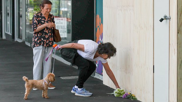 Geraldine Maguire, right, lays a floral tribute at the Niddrie practice where a fatal car crash occurred on Monday, December 8.