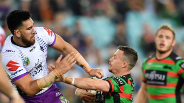 Playing above his weight: Damien Cook clashes with the Storm's Nelson Asofa-Solomona