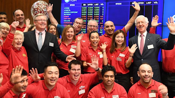 Coles managing director Steven Cain (in suit, left) and chairman James Graham (right) with Coles staff at its ASX listing ceremony on Wednesday. 